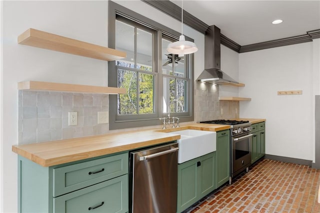 kitchen with open shelves, stainless steel appliances, butcher block counters, green cabinetry, and wall chimney exhaust hood