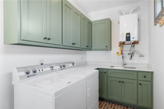 laundry area with brick floor, a sink, water heater, cabinet space, and washing machine and clothes dryer