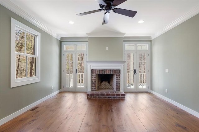 unfurnished living room featuring wood-type flooring, crown molding, and french doors