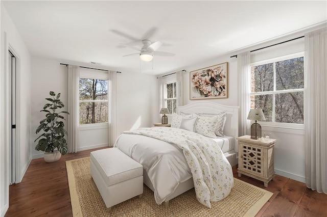 bedroom with ceiling fan, baseboards, and wood finished floors