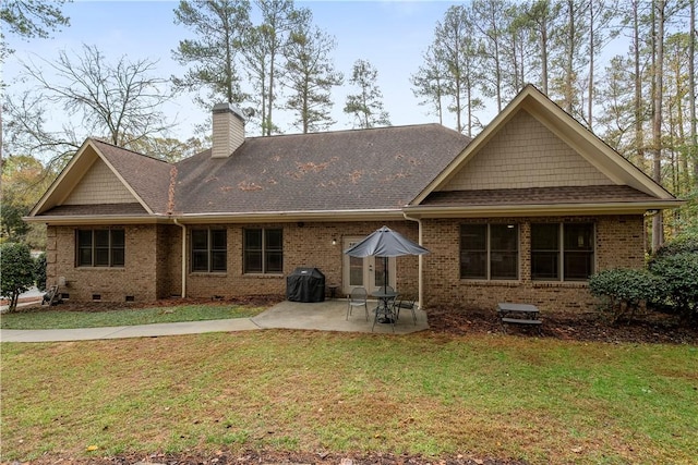 rear view of house featuring a chimney, crawl space, a yard, a patio area, and brick siding