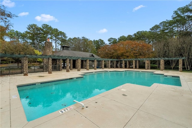 community pool featuring fence and a patio