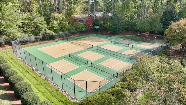 view of tennis court featuring community basketball court and fence