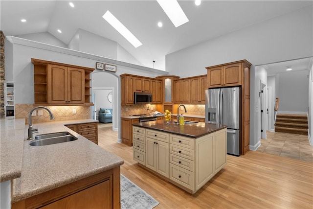 kitchen with open shelves, appliances with stainless steel finishes, a skylight, and a sink