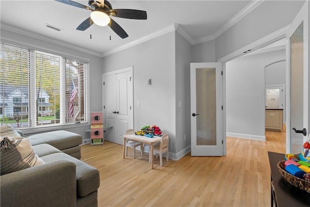 interior space with light wood-type flooring, visible vents, and crown molding