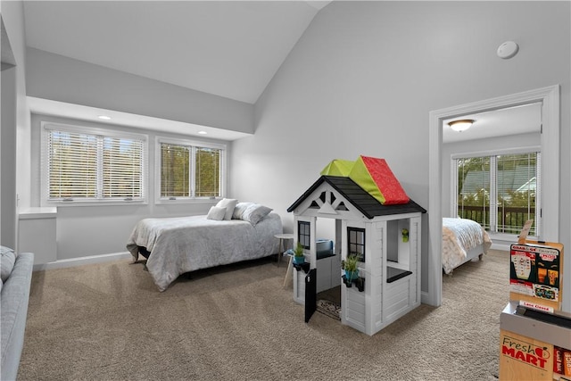 carpeted bedroom featuring high vaulted ceiling and baseboards