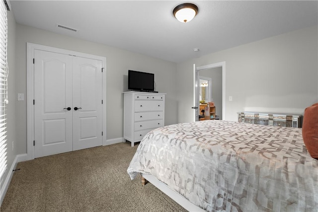 carpeted bedroom featuring visible vents, baseboards, and a closet