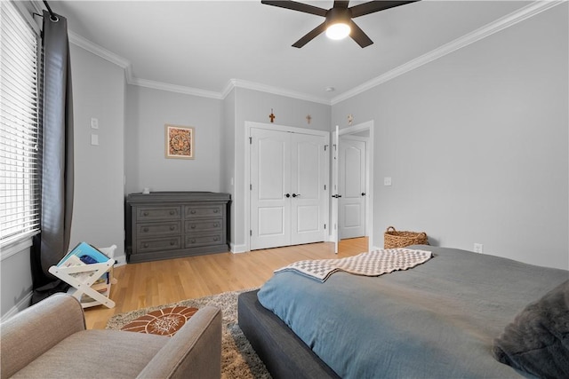 bedroom featuring baseboards, ceiling fan, wood finished floors, crown molding, and a closet