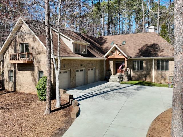 view of front of home with driveway and brick siding