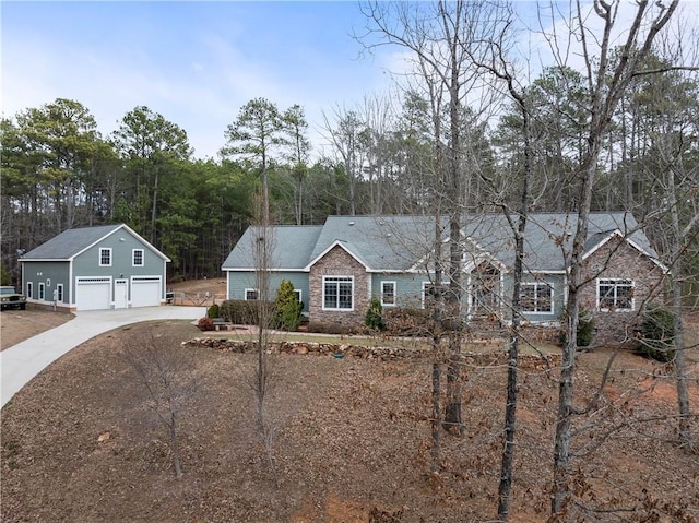 ranch-style home featuring a garage and an outbuilding