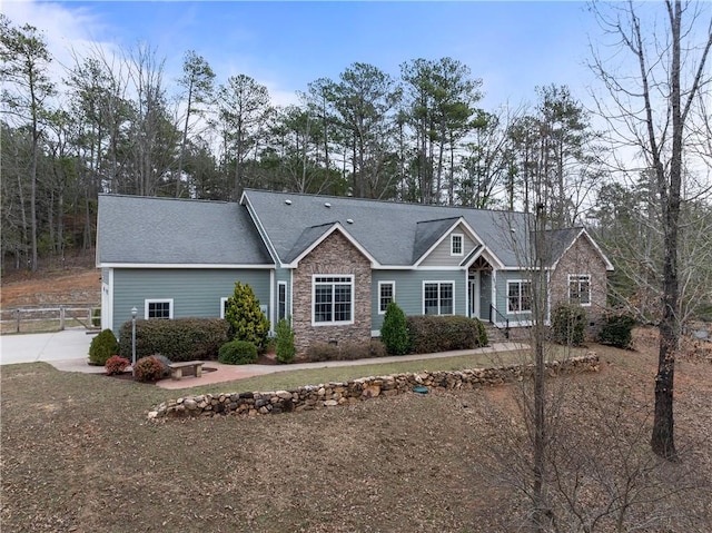 view of front facade featuring stone siding and fence