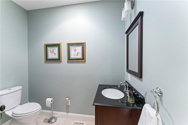 half bath with baseboards, vanity, toilet, and tile patterned floors