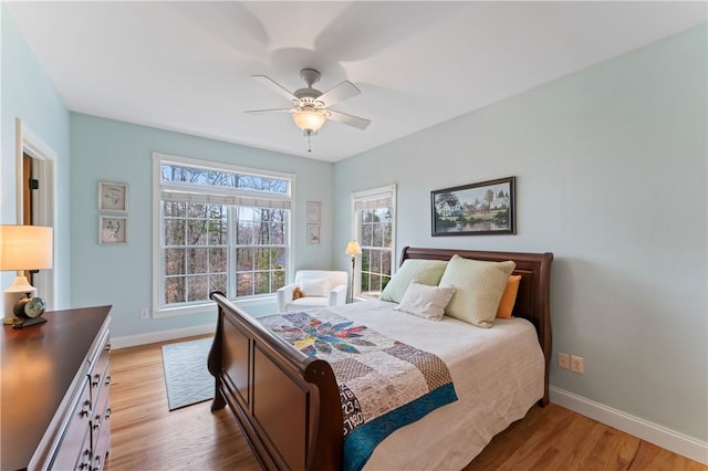 bedroom featuring ceiling fan, light wood finished floors, and baseboards