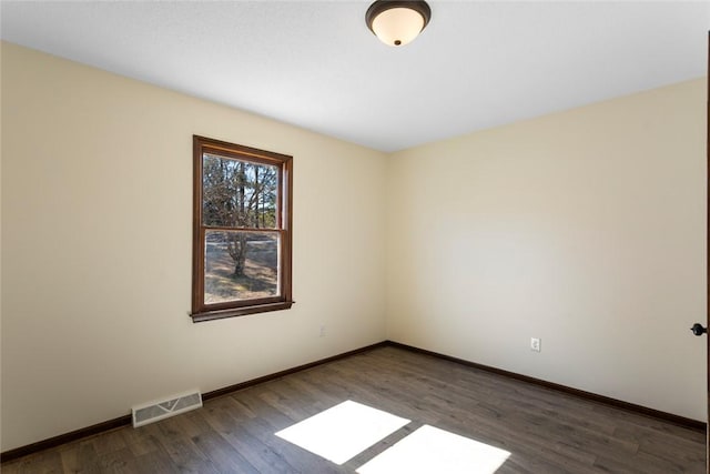 unfurnished room with visible vents, baseboards, and wood finished floors