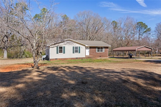 view of front facade with a carport, a front yard, crawl space, and driveway