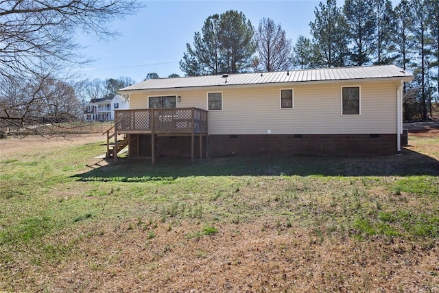 back of house with crawl space, a wooden deck, metal roof, and a yard