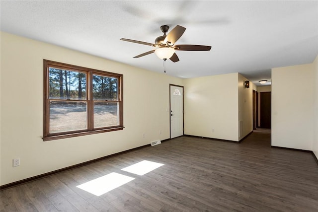 empty room with visible vents, baseboards, ceiling fan, and wood finished floors