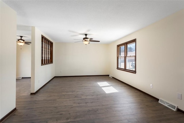 empty room featuring baseboards, visible vents, ceiling fan, and wood finished floors