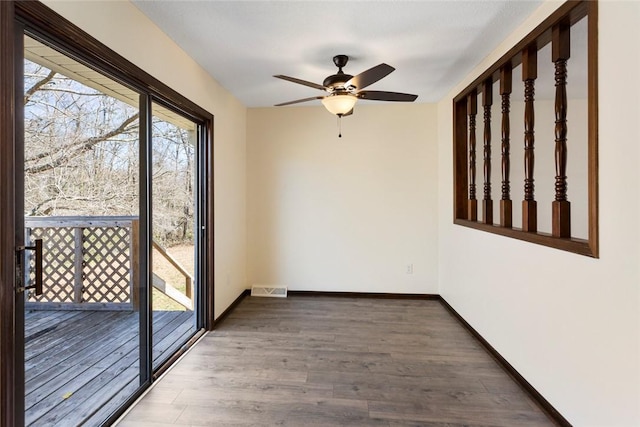 spare room with visible vents, ceiling fan, baseboards, and wood finished floors