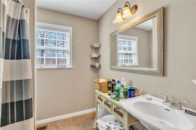 full bath featuring visible vents, baseboards, a shower with shower curtain, tile patterned floors, and a sink