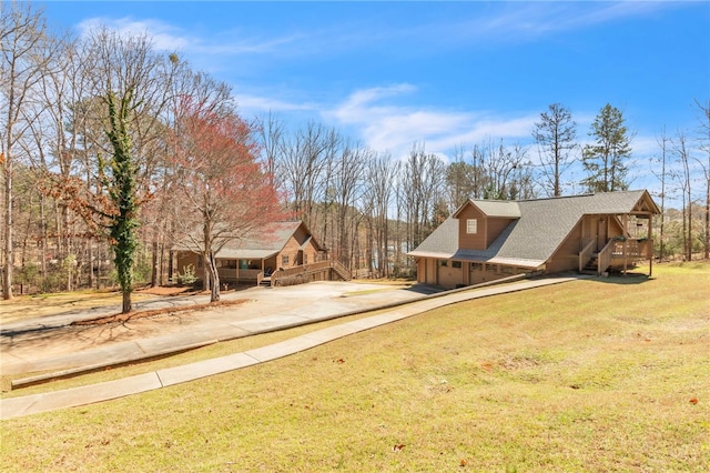 view of yard featuring a garage and concrete driveway