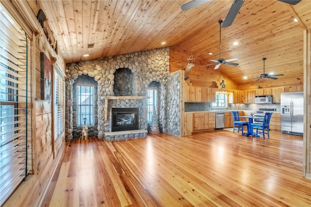 unfurnished living room with ceiling fan, a stone fireplace, high vaulted ceiling, light wood-type flooring, and wooden ceiling