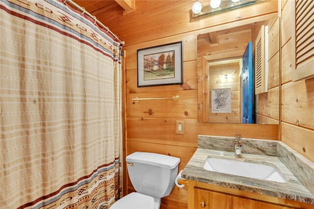 bathroom with a shower with curtain, wood walls, vanity, and toilet