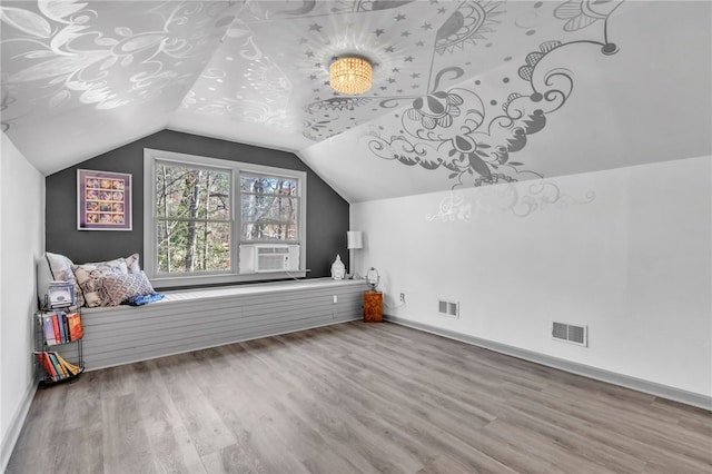 bonus room featuring lofted ceiling, baseboards, visible vents, and wood finished floors