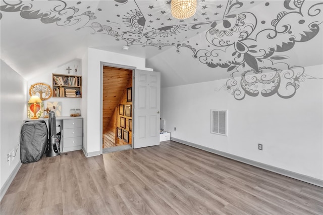 additional living space featuring visible vents, vaulted ceiling, baseboards, and wood finished floors