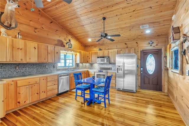 kitchen featuring stainless steel appliances, a sink, and light brown cabinetry