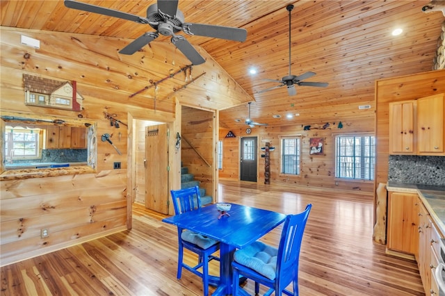 dining area with stairway, wooden ceiling, and wooden walls