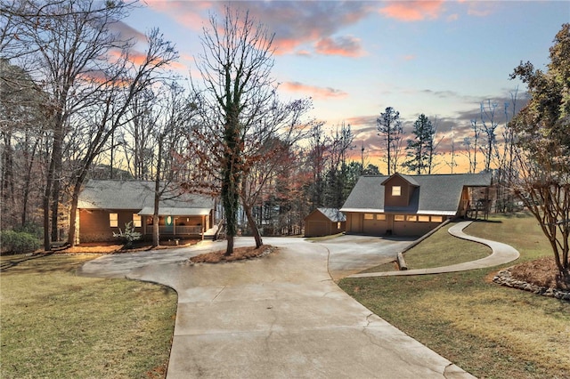 view of home's community with driveway, a garage, and a lawn