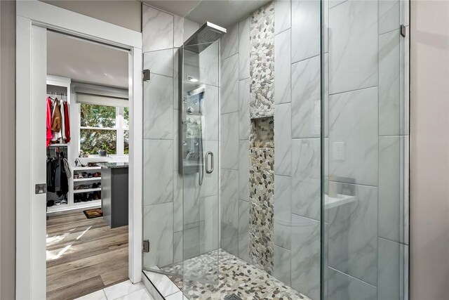 full bathroom with a shower stall and wood finished floors