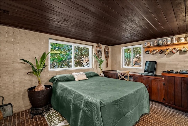 bedroom with brick wall, wooden ceiling, and brick floor