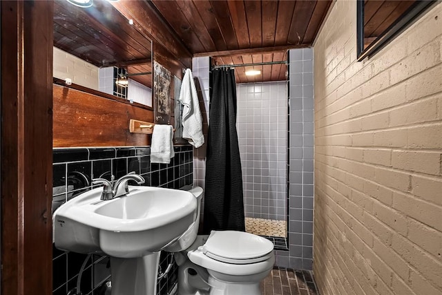 bathroom with brick wall, wooden ceiling, a tile shower, and toilet