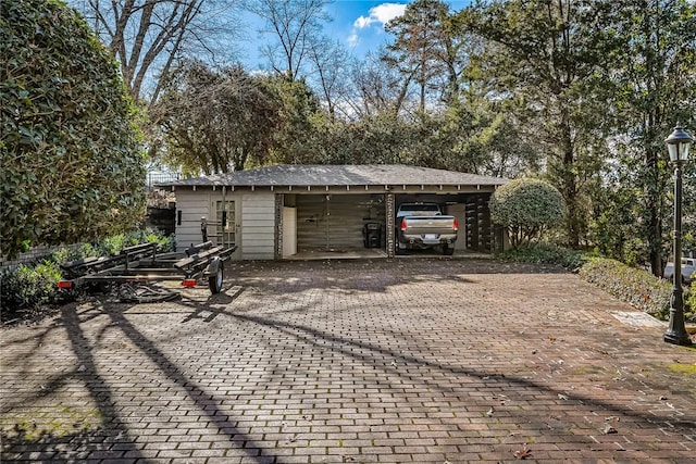 garage featuring a carport and decorative driveway