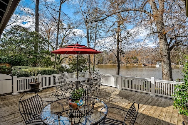 wooden terrace with outdoor dining space and a water view