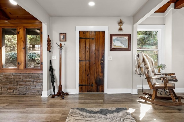 foyer entrance featuring baseboards and wood finished floors