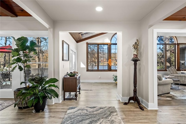 interior space featuring lofted ceiling with beams, baseboards, wood finished floors, and recessed lighting