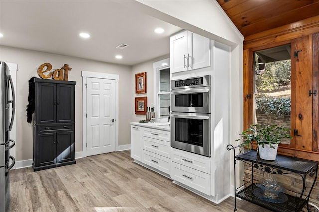 kitchen with light wood finished floors, recessed lighting, visible vents, appliances with stainless steel finishes, and white cabinetry