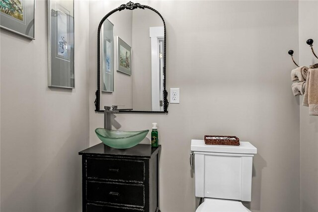 half bathroom with vanity and toilet