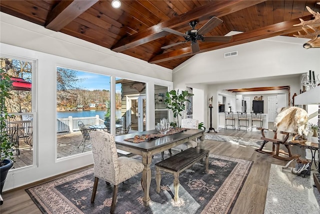 dining area featuring vaulted ceiling with beams, visible vents, and wood finished floors