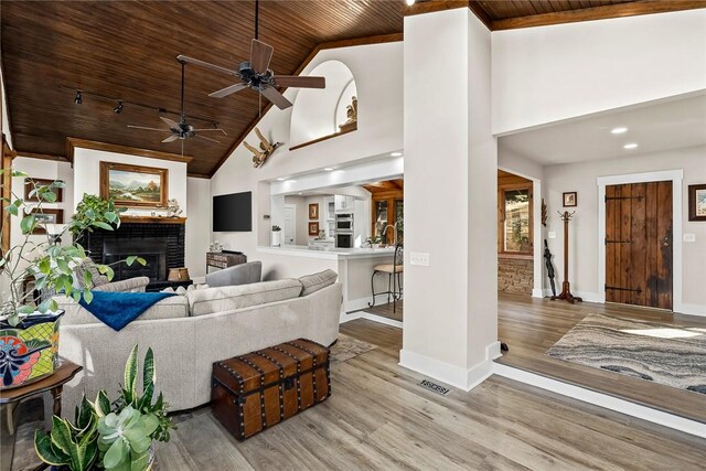 living room with wood ceiling, a fireplace, baseboards, and wood finished floors