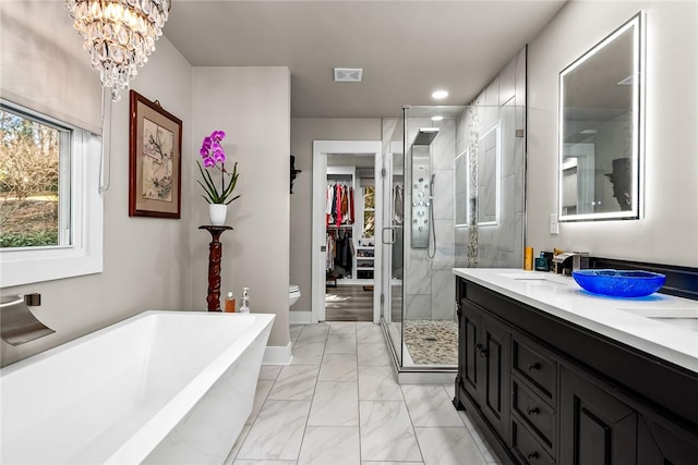 bathroom featuring a freestanding tub, vanity, marble finish floor, a shower stall, and an inviting chandelier