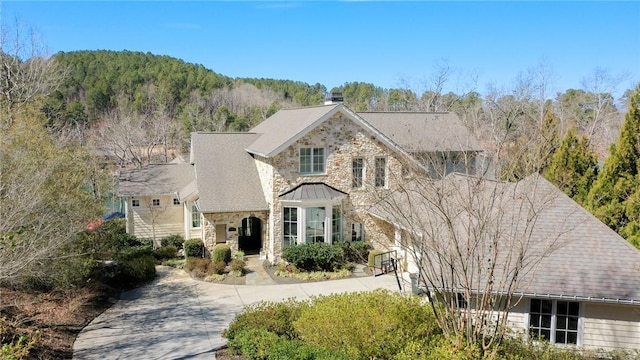 traditional home with stone siding and concrete driveway