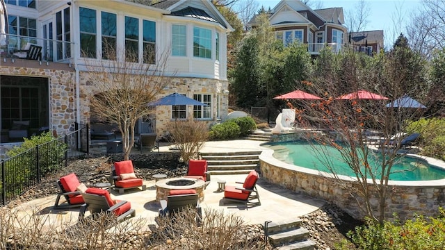 view of pool featuring a fenced in pool, a patio area, fence, and a fire pit