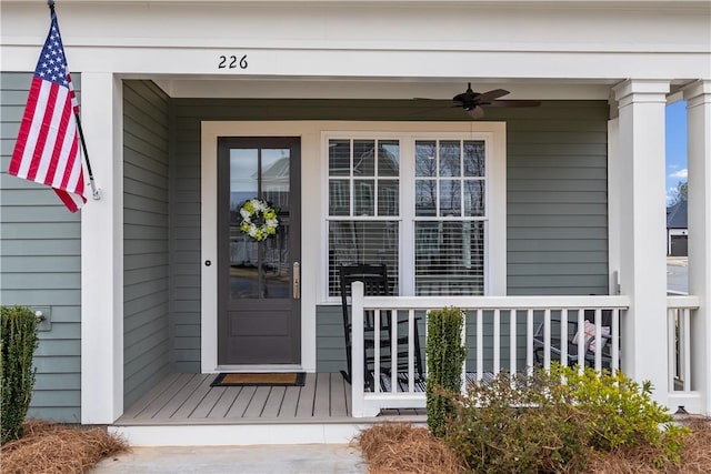 entrance to property with ceiling fan and a porch