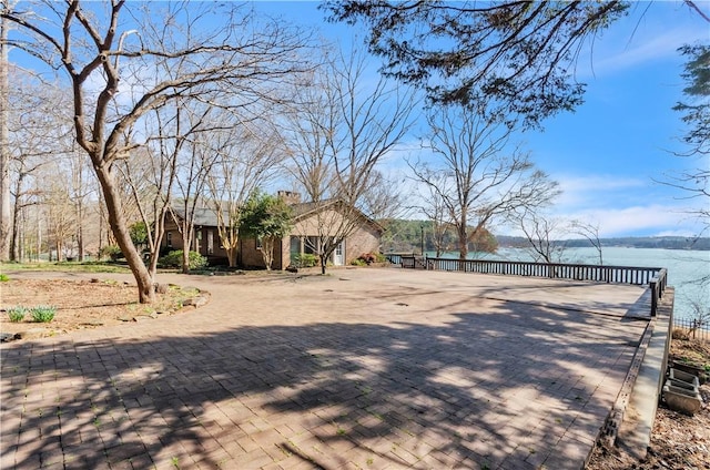 view of yard with decorative driveway and a water view