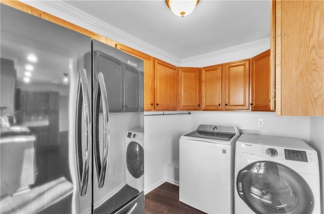 clothes washing area with crown molding, dark wood finished floors, cabinet space, and washer and dryer