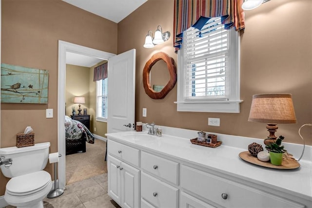 ensuite bathroom with tile patterned flooring, vanity, toilet, and a healthy amount of sunlight